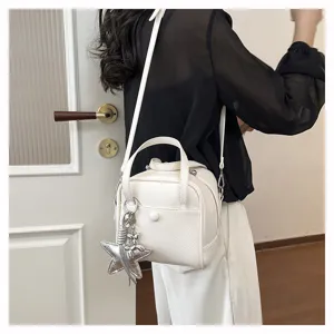 Detailed view of white textured shoulder bag with star pendant, casual daily style design.