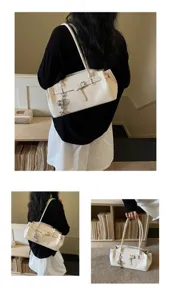 Detailed view of white textured shoulder bag with metal buckle strap and pendant charm.