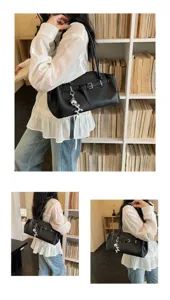 Chic black leather underarm shoulder bag with metal buckle and cute silver charm detail.