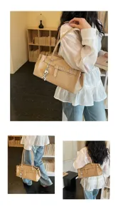 Detailed view of chic khaki shoulder bag with stylish belt buckle and cute silver charm.