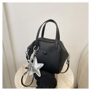 Chic black leather handbag featuring silver star charm, elegant top handle crossbody bag.