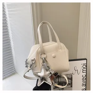 White PU leather handbag with chic silver star charm, elegant top handle and shoulder strap.