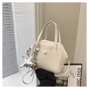Minimalist white top handle shoulder bag featuring a chic silver star charm and crossbody strap.