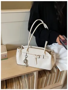 Chic white leather shoulder bag for women, stylish commuter tote with metal buckle and cute pendant.