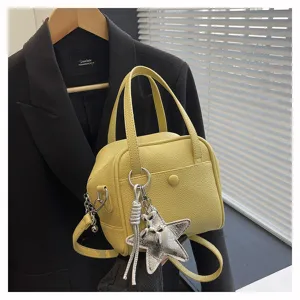 Stylish yellow leather handbag with metal star charm, versatile shoulder and crossbody bag.