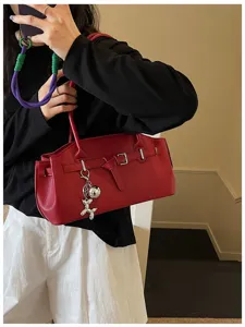 Stylish red leather shoulder bag underarm bag with metal buckle and cute keychain for women.
