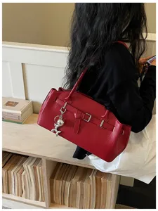 Detailed view of the red leather east-west shoulder bag worn by a model in a stylish interior.