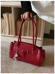 Red leather shoulder underarm bag stylish commute tote handbag with metal buckle charm.