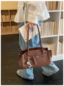 Chic brown leather shoulder bag for women, stylish casual underarm handbag with charms.
