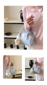 Light blue handheld baguette shoulder bag detail featuring a cute plush bow charm accessory.