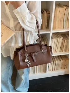 Stylish brown leather shoulder bag for women, trendy commuter tote with chic belt detail.