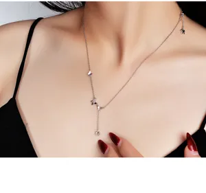 Nahaufnahme Detailaufnahme einer silbernen Halskette mit Schmetterlingsanhängern und Zirkon.