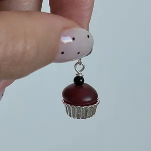 Primo piano dettagliato del simpatico ciondolo in argento a forma di cupcake ben rifinito.