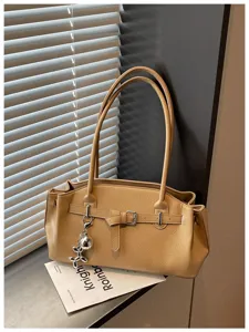 Detailed view of stylish PU leather shoulder bag with metallic buckle and cute charm.