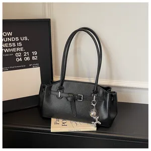 Black textured shoulder bag for women, stylish tote bag with buckle and cute keychain.