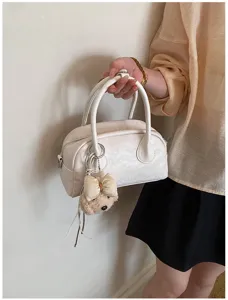 Chic white mini boston handbag with bow plush pendant, stylish PU leather crossbody bag for women.