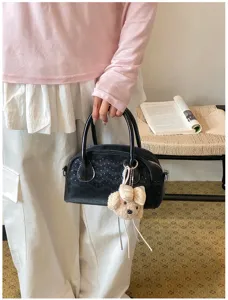 Chic minimalist black handbag for women, premium leather top-handle bag with cute plush charm.