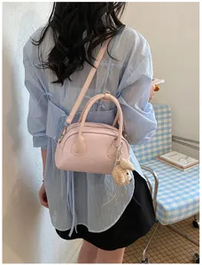 Stylish pink shoulder bag with cute plush charm, premium casual crossbody design for daily wear.