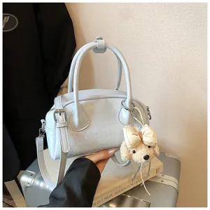 Light blue boston handbag with cute plush dog charm, stylish casual shoulder crossbody bag.