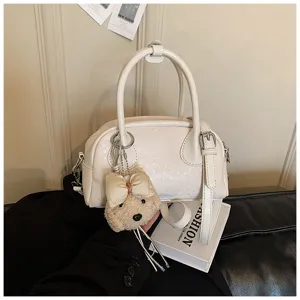 White PU leather shoulder handbag detail with cute plush bear pendant and elegant style.