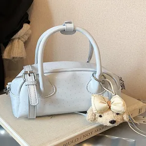 Fashionable light blue women handbag with cute dog charm, casual top handle crossbody bag.