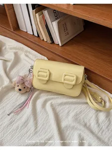 Trendy vintage-style women's shoulder bag with cute bear pendant and chic buckle design.