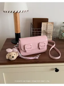 Chic pink PU leather crossbody shoulder bag with double buckles and cute puppy plush pendant.