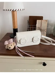 Trendy white vintage shoulder bag with cute bear charm, versatile crossbody bag for women.