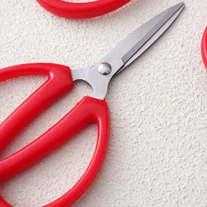 Professional household and office utility scissors with bright red handles and sharp steel blades.