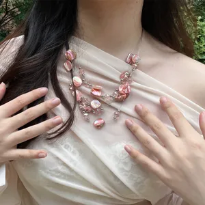 Detailed shot of multi-layer necklace with pink irregular shell beads and crystal beads.