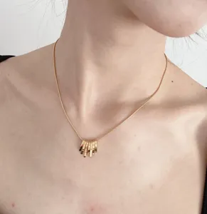 Collier ras du cou doré à pendentifs multiples, style rétro minimaliste et élégant.