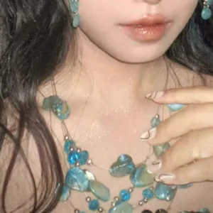Detail shot of blue crystal beaded irregular shell layered necklace and matching earrings.