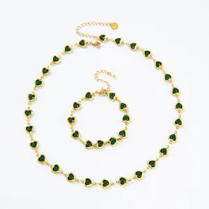 Detailaufnahme von vergoldetem Edelstahlschmuck Set mit grünen Herz Kristallsteinen.
