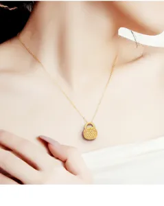 Detailed view of vintage gold lock pendant necklace, delicate hollow design, elegant jewelry.