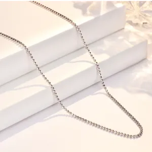 Close-up detail shot of a sparkling faceted silver ball chain necklace on a white display block.