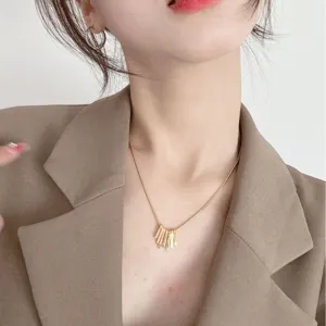 Élégant collier ras de cou doré à pendentif pompon pour femme, bijou minimaliste et chic.