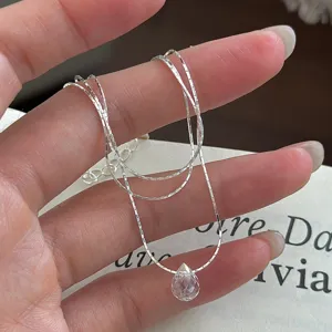 Silver teardrop crystal necklace detail shot, delicate jewelry close-up showcasing sparkle.