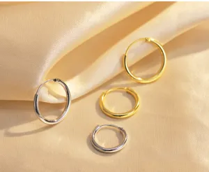 Detailansicht minimalistischer 925er Silber-Creolen, klassisches rundes Gold-Design.