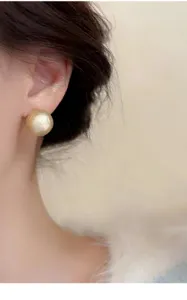 Nahaufnahme des matt strukturierten goldenen Kugel-Ohrrings, eleganter Vintage-Stil.