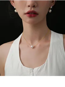 Nahaufnahme Detail der eleganten Einzelperle Anhänger Halskette und Perlenohrringe getragen.