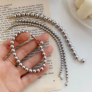 Elegantes graues Perlenarmband-Set mit glänzenden Perlen und Goldverschluss, schick und vielseitig.