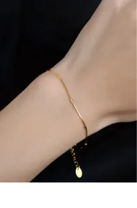 Close-up detail view of the shimmering sterling silver snake bone chain bracelet on wrist.