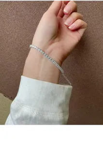 Silbernes Tennisarmband Detail, funkelnde Zirkoniasteine am Handgelenk, eleganter Schmuck.