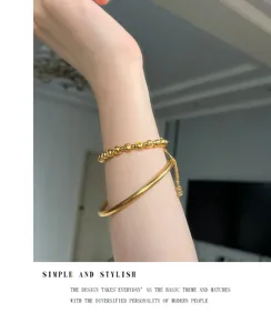 Toma de detalle de pulsera de doble capa con cuentas doradas y brazalete, elegante.