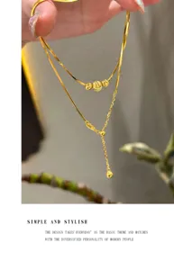 Close-up detail van dubbellaagse slangenketting ketting met delicate kralen en kwastje.