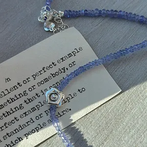 Squisita collana girocollo di perle tanzanite con ciondolo fiore argento e stile.