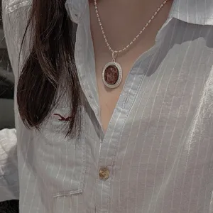 Nahaufnahme einer S925 Sterlingsilber Perlenkette mit retro ovalem Rutilquarz Anhänger Halskette.
