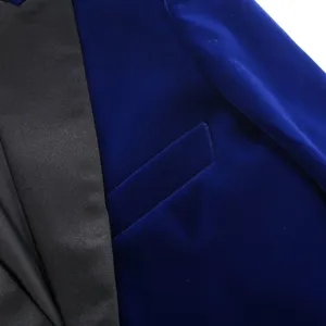 Royal blue velvet blazer detail close-up showing black satin shawl lapel and chest pocket.