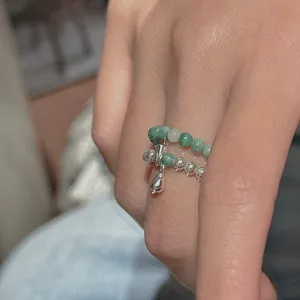 Gros plan détail de la bague de perles double couche avec pendentif goutte argenté style rétro.