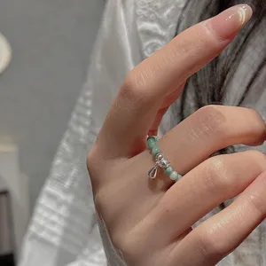 Bague en perles en argent sterling minimaliste avec petit pendentif, détail main.